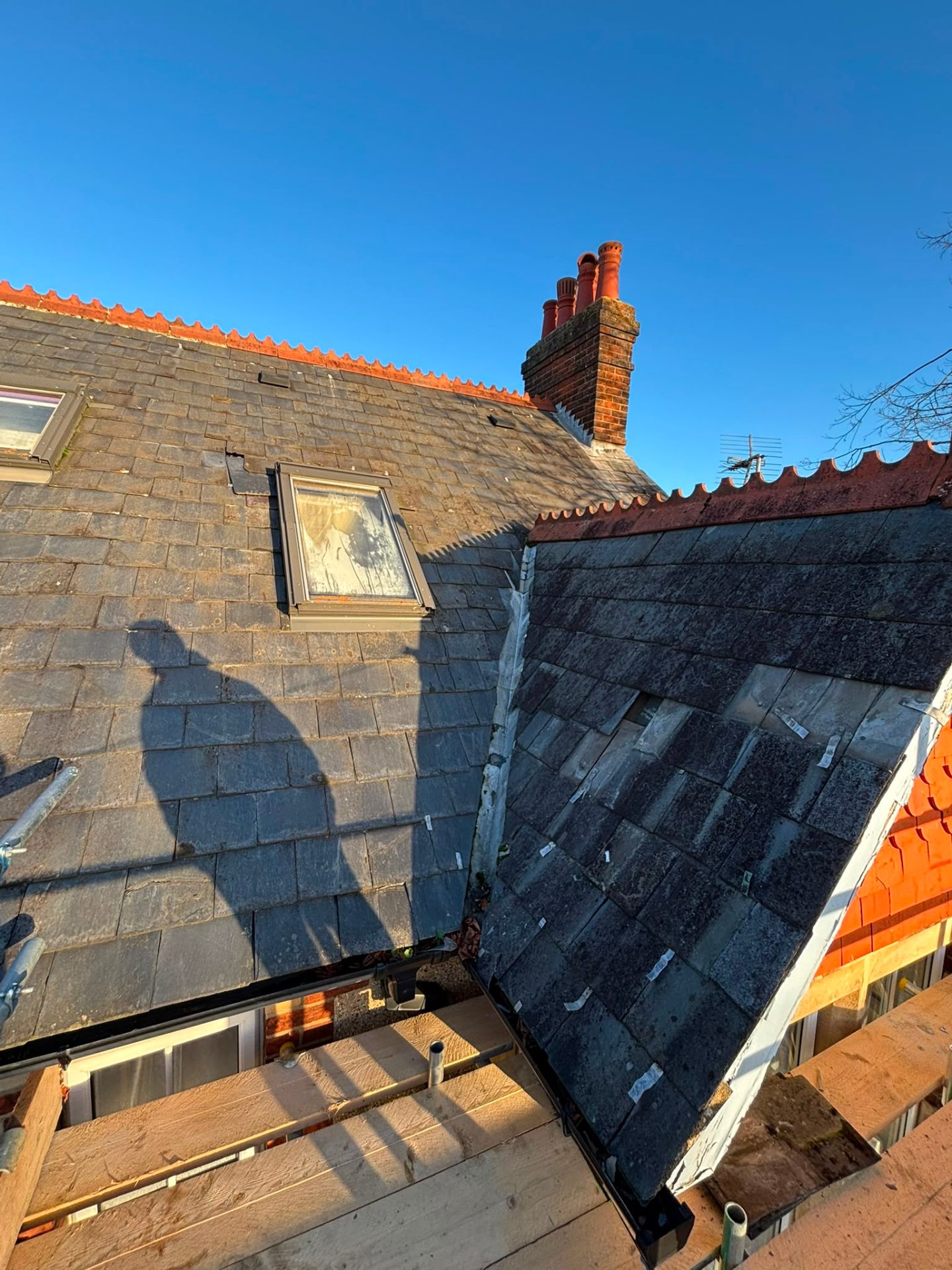 Slate roof with slipped and broken slates near a chimney requiring repair — White Horse Roofing, Oxfordshire